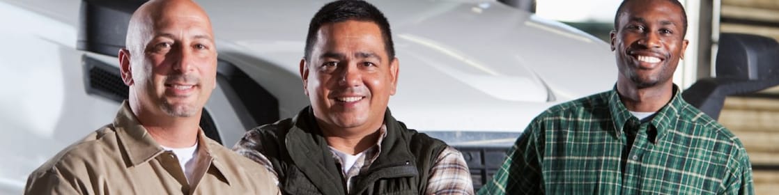 Three men standing in front of white truck cab