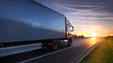 Heavy duty freight truck on a highway at sunrise