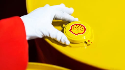 A Shell expert adjusts the lid of a barrel of lubricant displaying the Shell logo