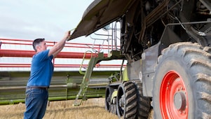 Farmer working with agriculture equipment in field