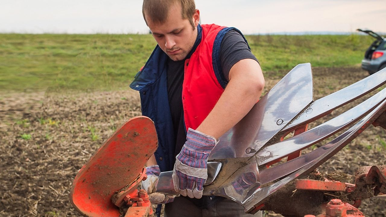 Farmer maintaining equipment
