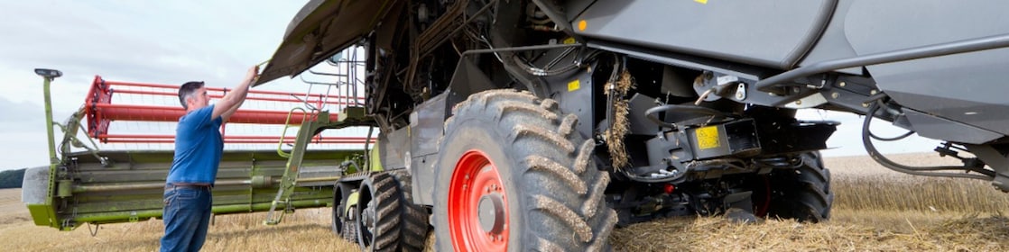 Farmer working with harvesting equipment in field