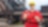 man in red coverall and yellow hard hat standing in front of steel mill