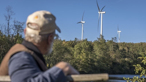 Man looking at mount storm wind turbines