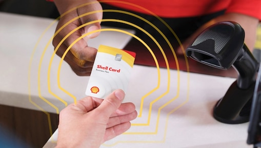 A person handing the Shell Card to a clerk at a Shell station