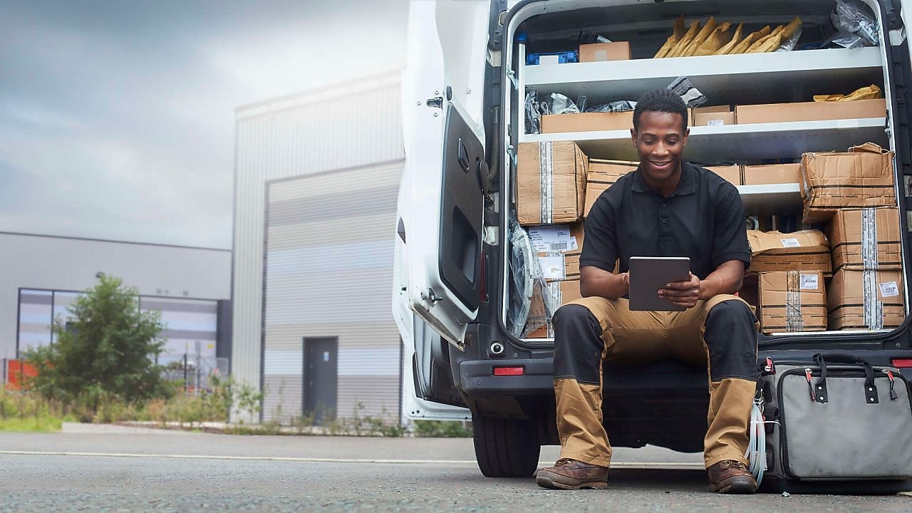 Man using iPad while sitting in delivery truck