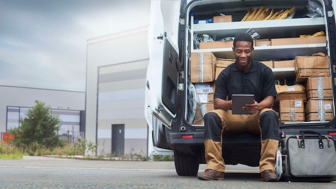 Man using iPad while sitting in delivery truck