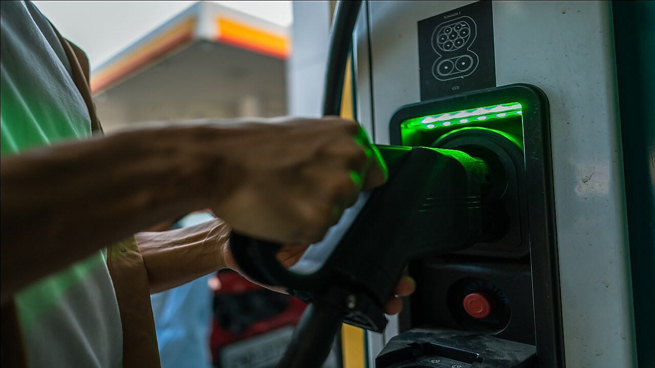 A person charging their vehicle at an EV charge point
