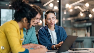 Team members reading on laptop
