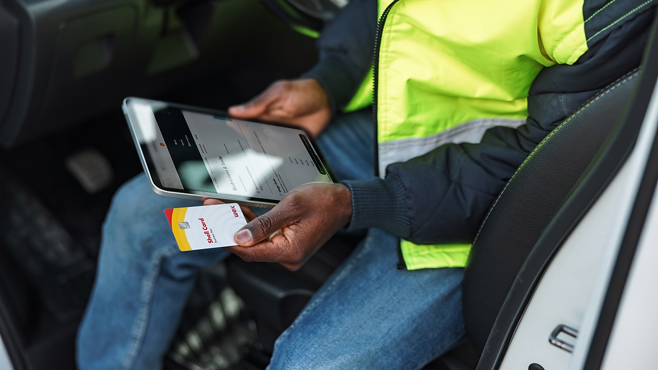 Fleet driver holding Shell card and tablet