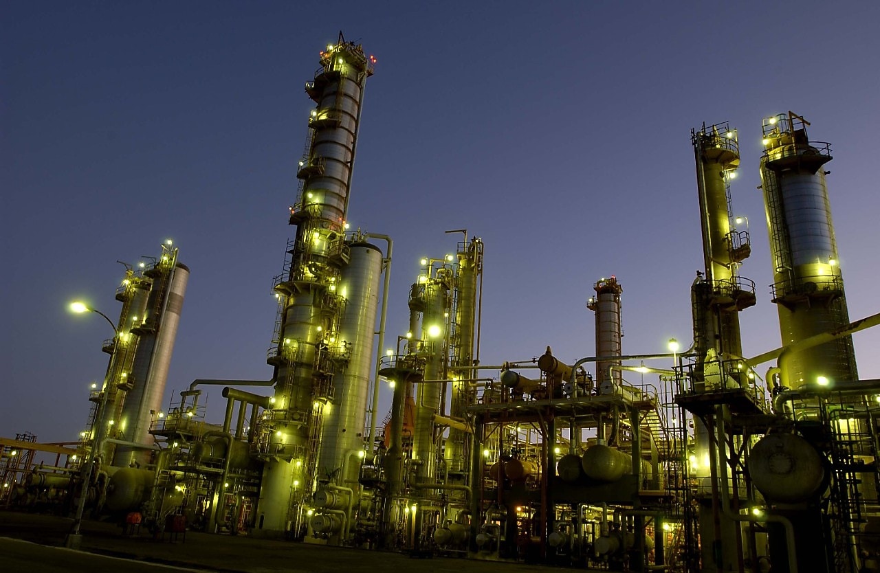a refinery at dusk, with lights on