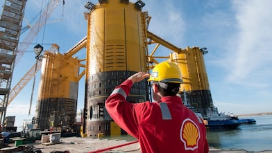 A Shell worker inspects the Olympus hull