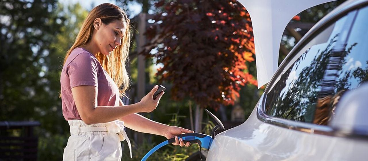 Woman fueling up electric vehicle