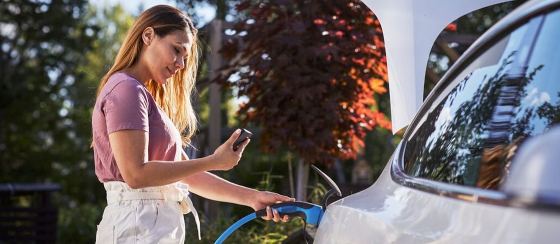 Woman fueling up electric vehicle