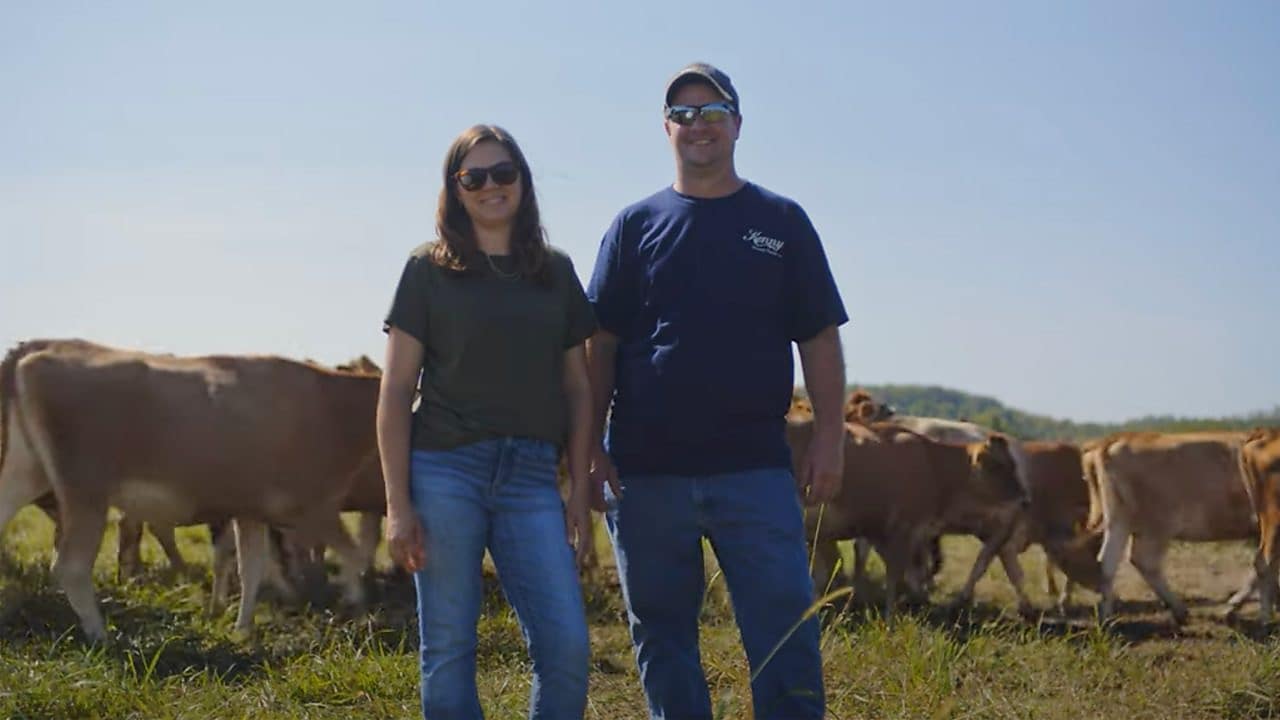 A man and woman standing in a field 