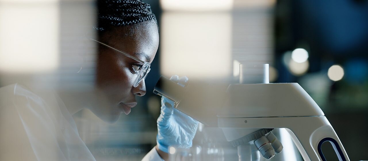 Woman looking into microscope