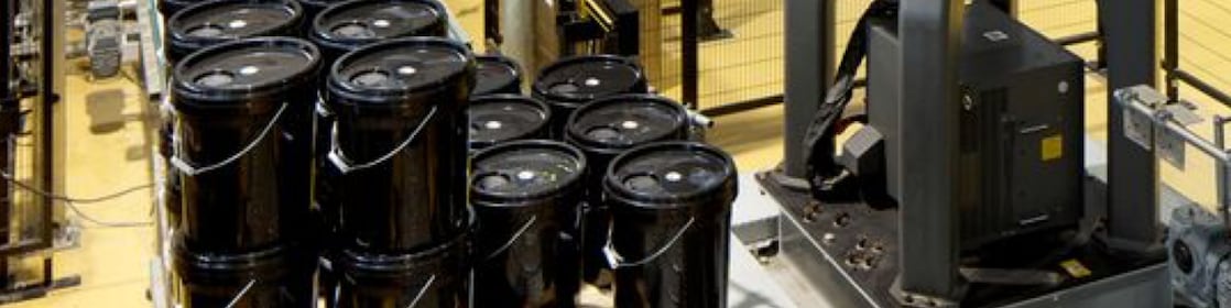 Black 5-gallon buckets in an industrial setting 