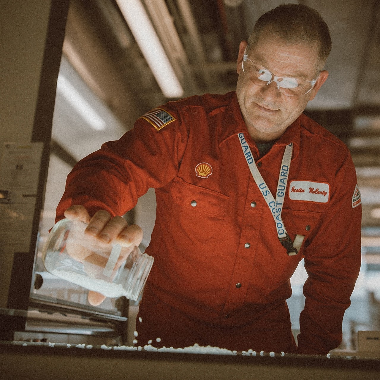 Man pouring plastic pellets out of a beaker