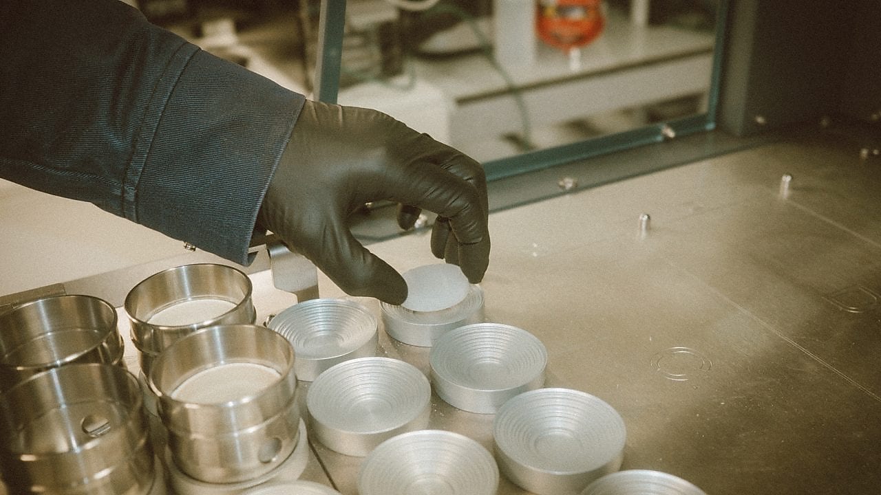 Gloved hand reaching for beakers