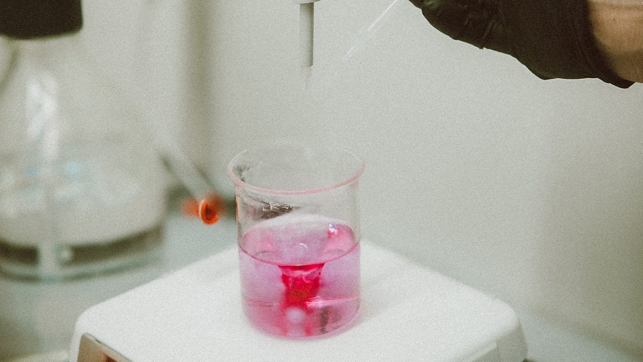 Shell Polymers employee holding beaker