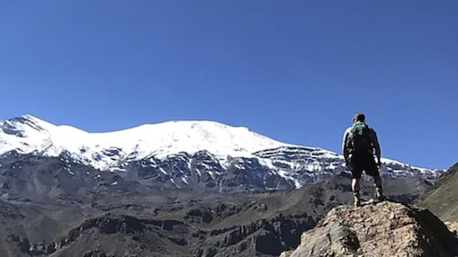 Elliot Carnevale standing on top of a mountain looking out