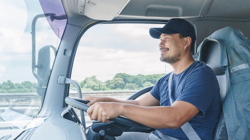 man smiling while driving truck