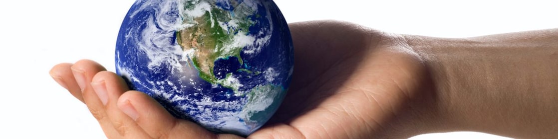 A hand holding a circular earth