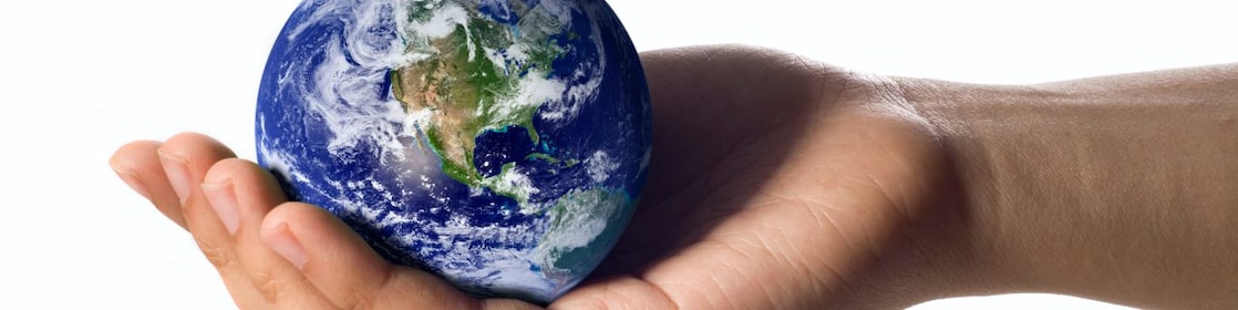 A hand holding a circular earth