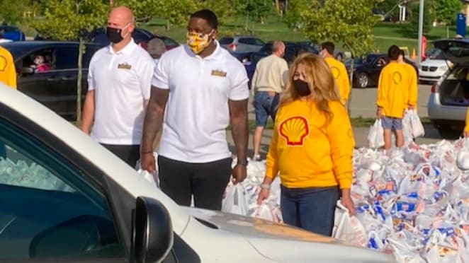 Chris Hoke (left), Arthur Moats (right) and a Shell Polymers volunteer wait with bags of food and supplies. Photo courtesy of Patti Conley and the BCT staff.²