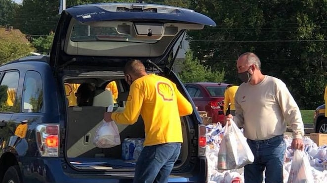 Shell Polymers’ volunteers loading food and supplies into a community member’s trunk.