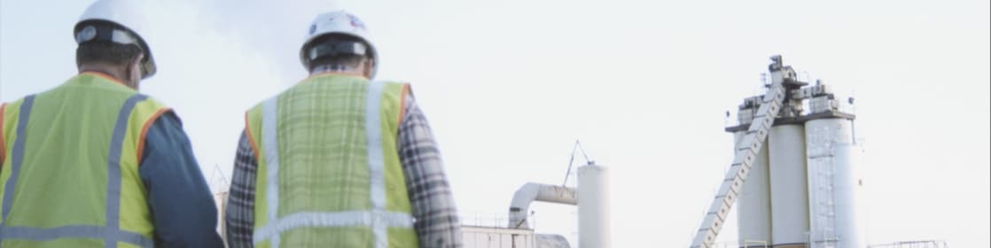 Two plastics manufacturer employees walking towards the plant