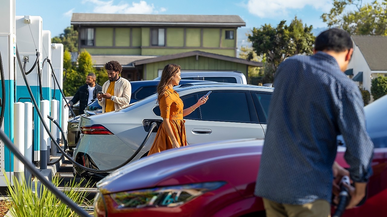 Multiple cars charging with drivers initiating charging sessions.