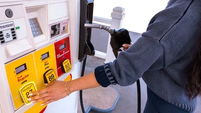 Woman select shell regular gas at a shell gas station