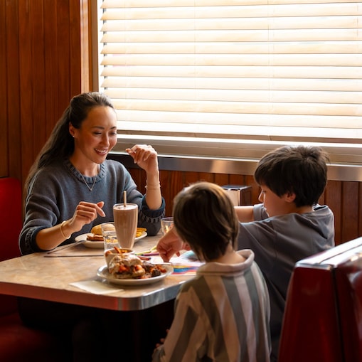 woman and children enjoy a meal in a restaurant
