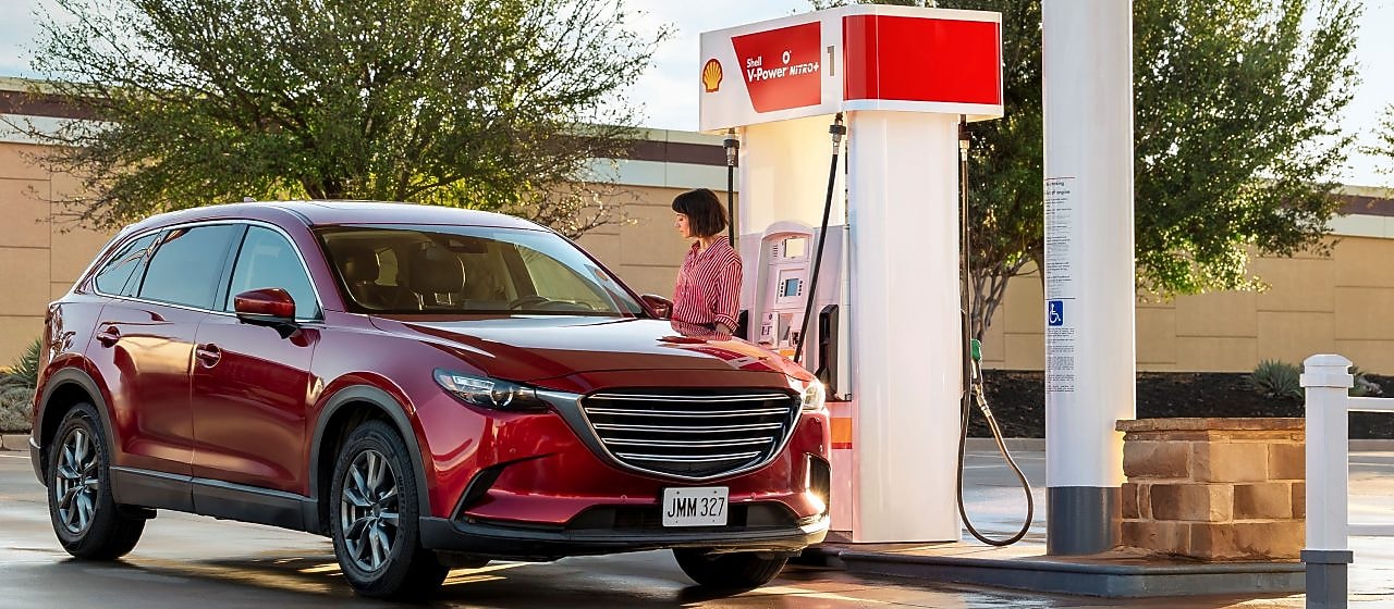Hand holding credit card at Shell pump