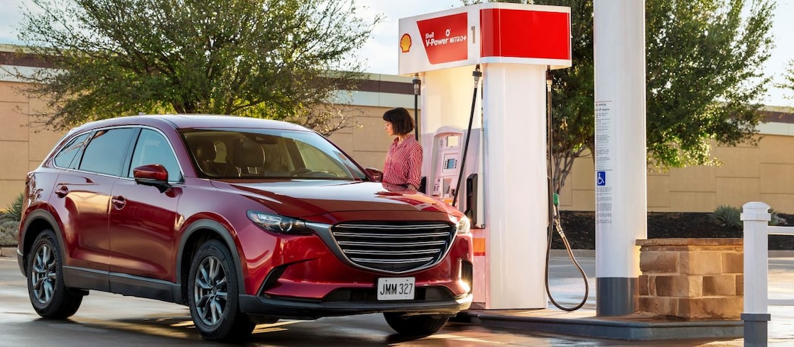 Hand holding credit card at Shell pump